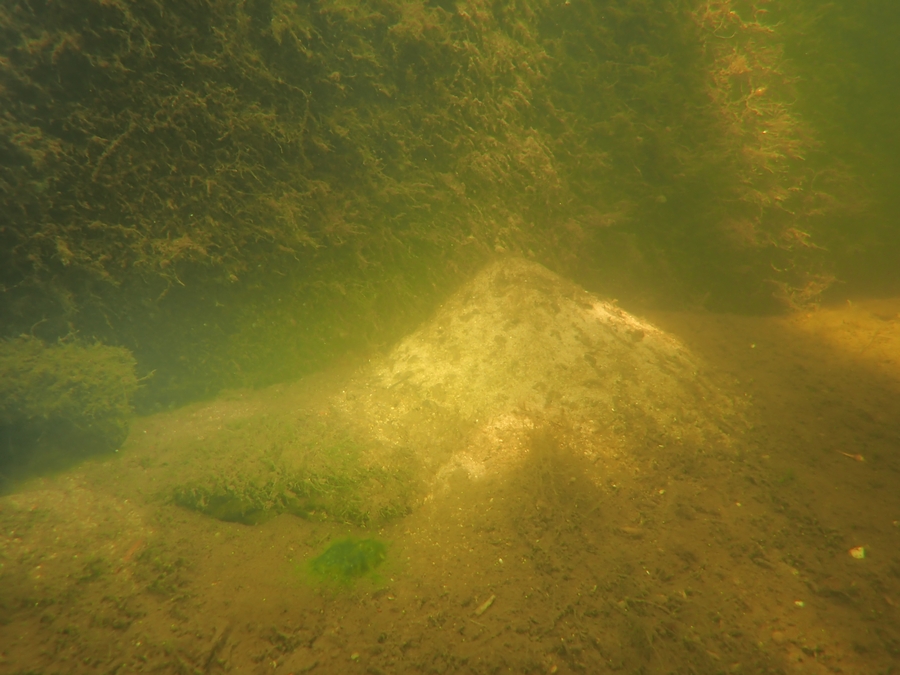 een flinke zandberg verraadt activiteiten van een rivierkreeft of wolhandkrab die de kademuur ondergraaft